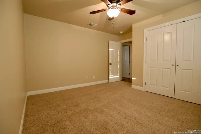 an empty room with a ceiling fan and a window