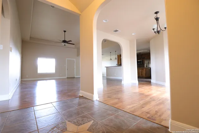 a view of a hallway with wooden floor and a living room