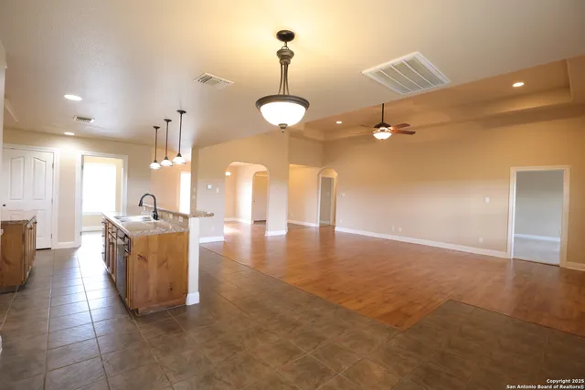 a view of a livingroom and a kitchen with furniture wooden floor