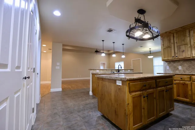a kitchen with stainless steel appliances granite countertop a sink and refrigerator