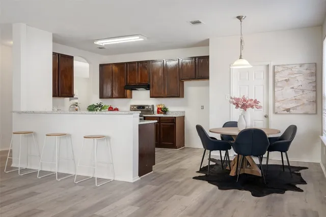 a kitchen with a table chairs refrigerator and cabinets