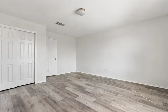 a view of empty room with wooden floor