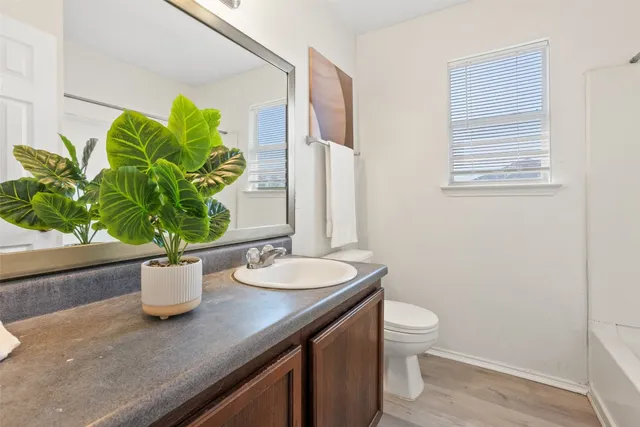 a bathroom with a granite countertop sink a toilet and a mirror