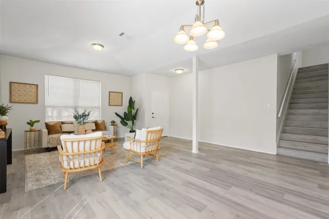 a living room with furniture and a chandelier