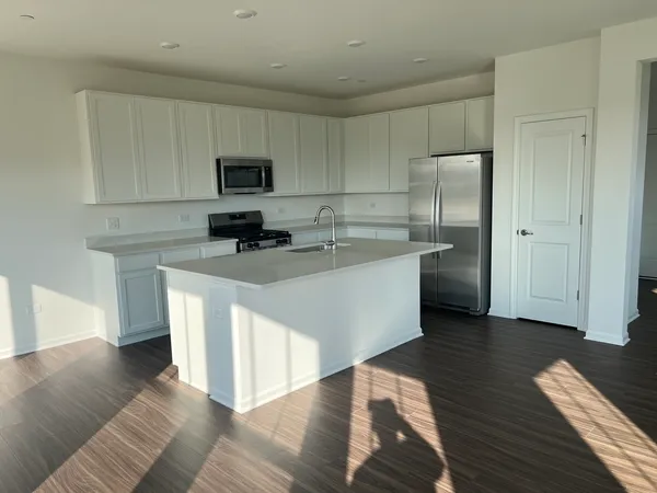 a kitchen with stainless steel appliances white cabinets a sink and a center island