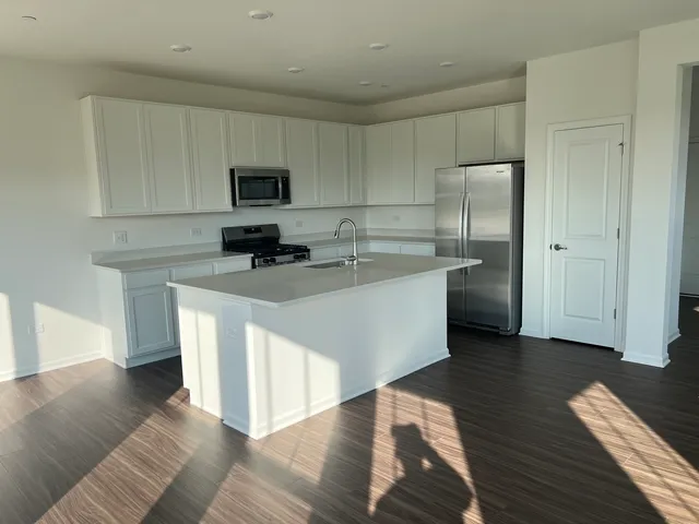 a kitchen with stainless steel appliances white cabinets a sink and a center island