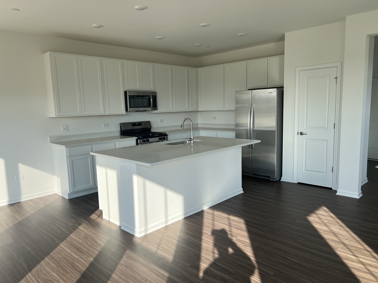 146 Henderson Street Oswego, IL 60543 - Photo 3 of 19 a kitchen with stainless steel appliances white cabinets a sink and a center island