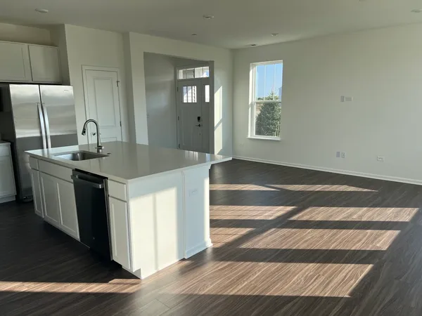 a kitchen with a sink cabinets and wooden floor