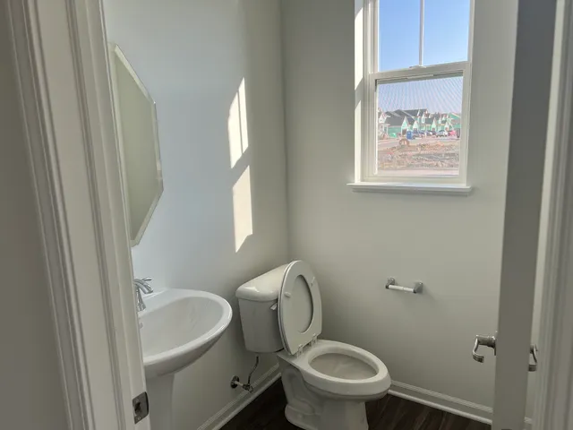 a white toilet sitting next to a bathroom sink and tub