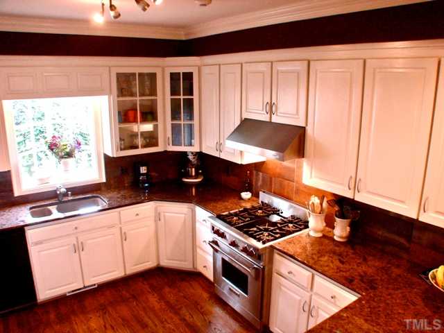 3316 Churchill Road Raleigh, NC 27607 - Photo 8 of 25 a kitchen with stainless steel appliances a stove a sink and white cabinets
