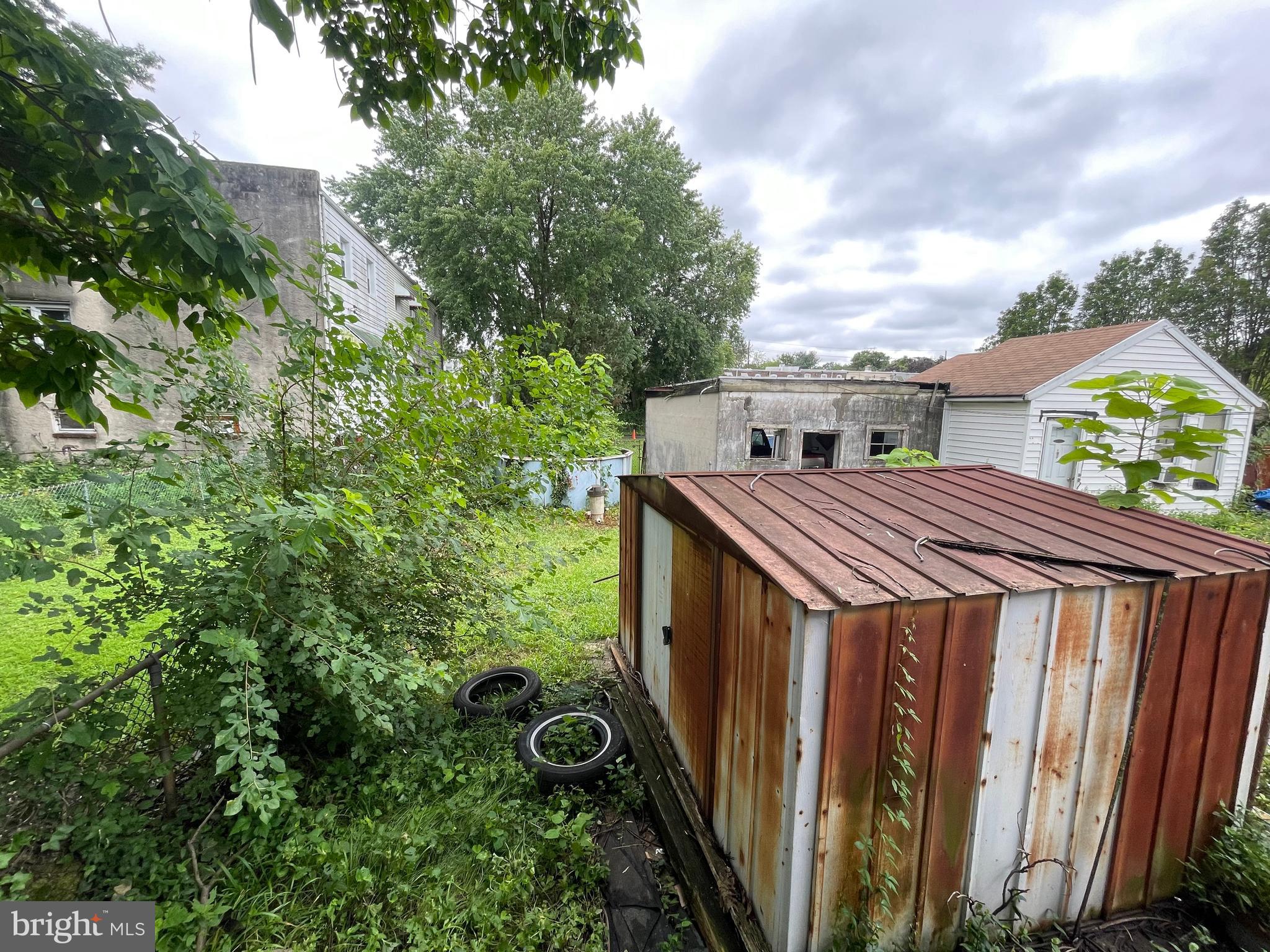 708 Jeffrey Street Chester, PA 19013 - Photo 4 of 13 a view of a wooden house with a small yard and large trees