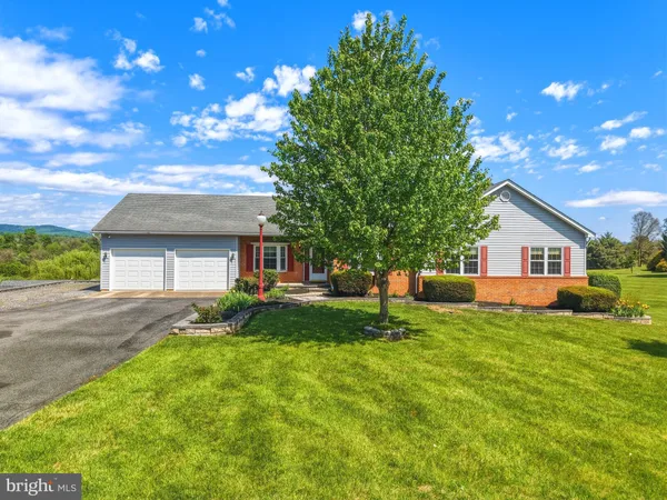 a front view of a house with a yard and trees
