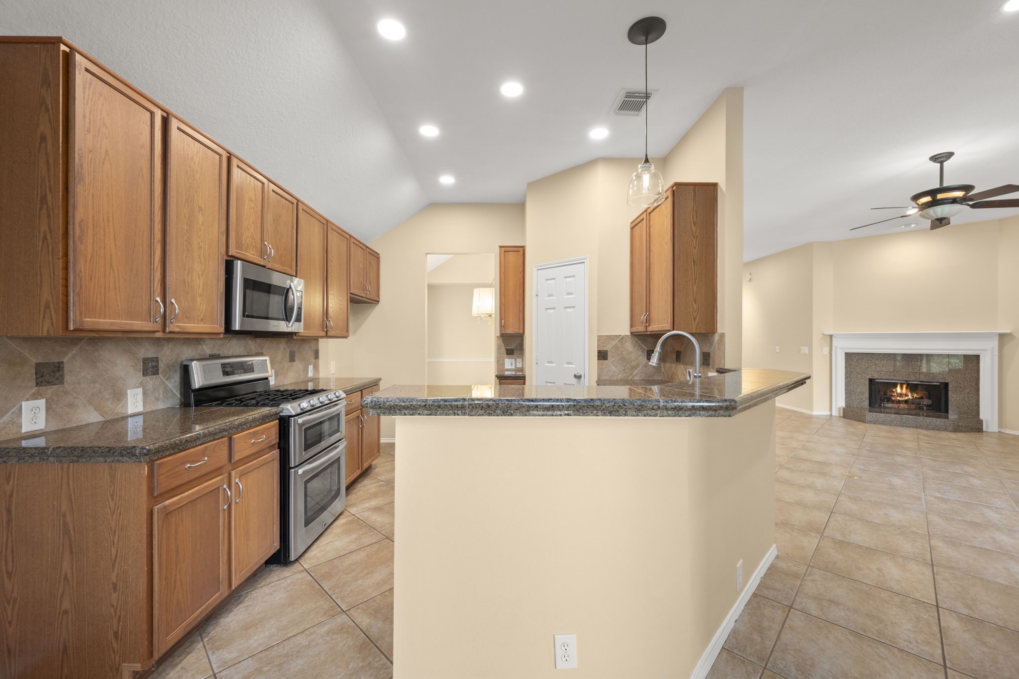2007 Louetta Spring Drive Spring, TX 77388 - Photo 17 of 50 Designed for both everyday living and entertaining, the kitchen offers granite countertops, tile backsplash with granite accents, abundant cabinetry, and a breakfast bar overlooking the family room.