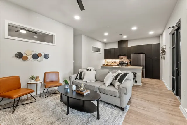 a living room with furniture and kitchen view