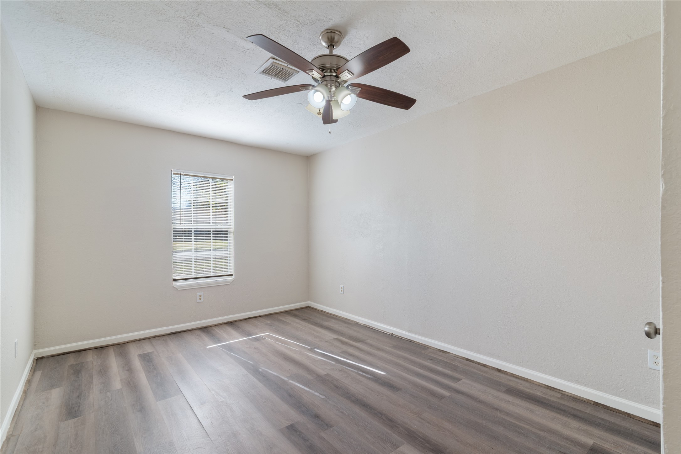 5825 Southurst Street Houston, TX 77033 - Photo 11 of 23 an empty room with wooden floor fan and windows