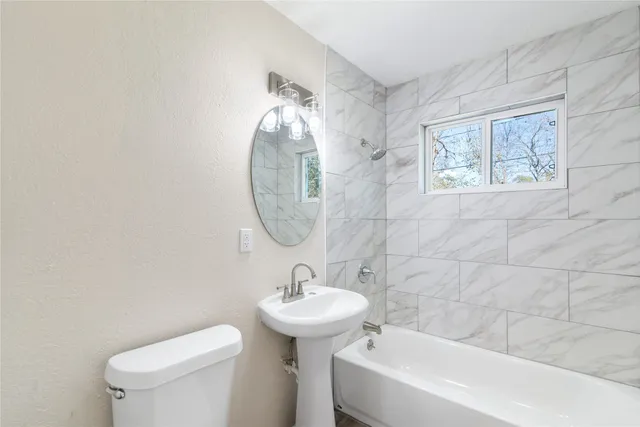 a bathroom with a sink mirror and toilet