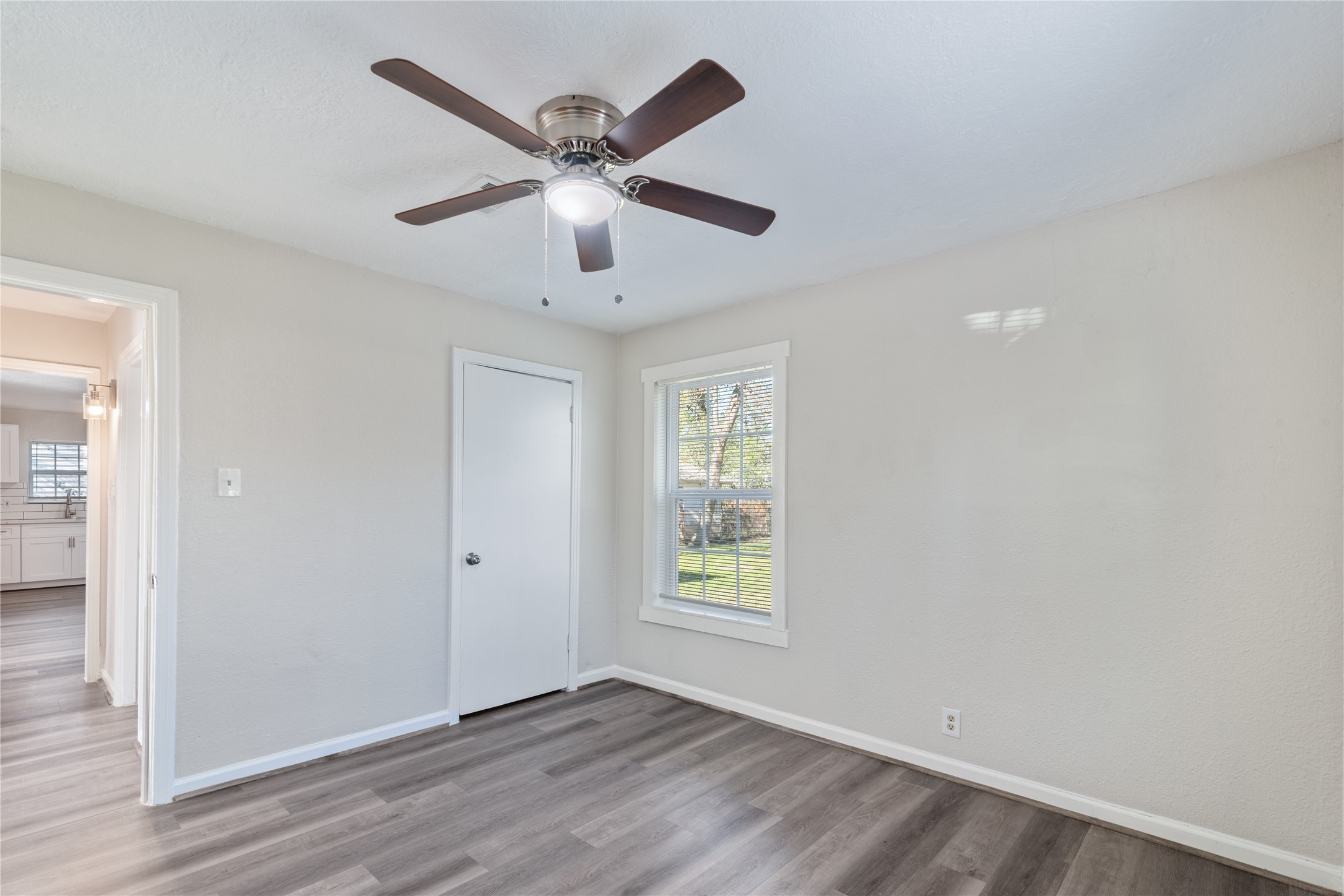5825 Southurst Street Houston, TX 77033 - Photo 18 of 23 an empty room with wooden floor chandelier fan and windows