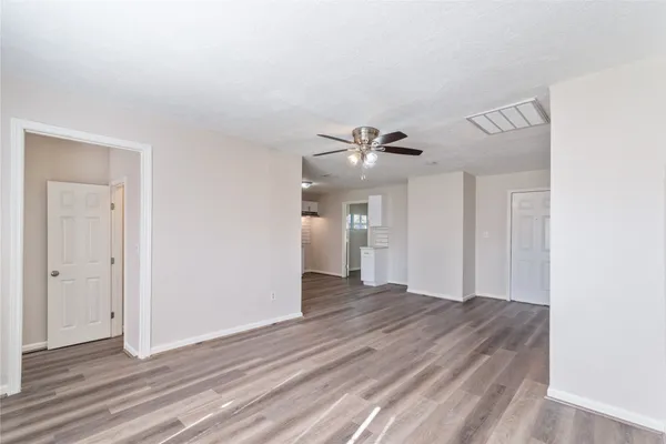 a view of an empty room with wooden floor