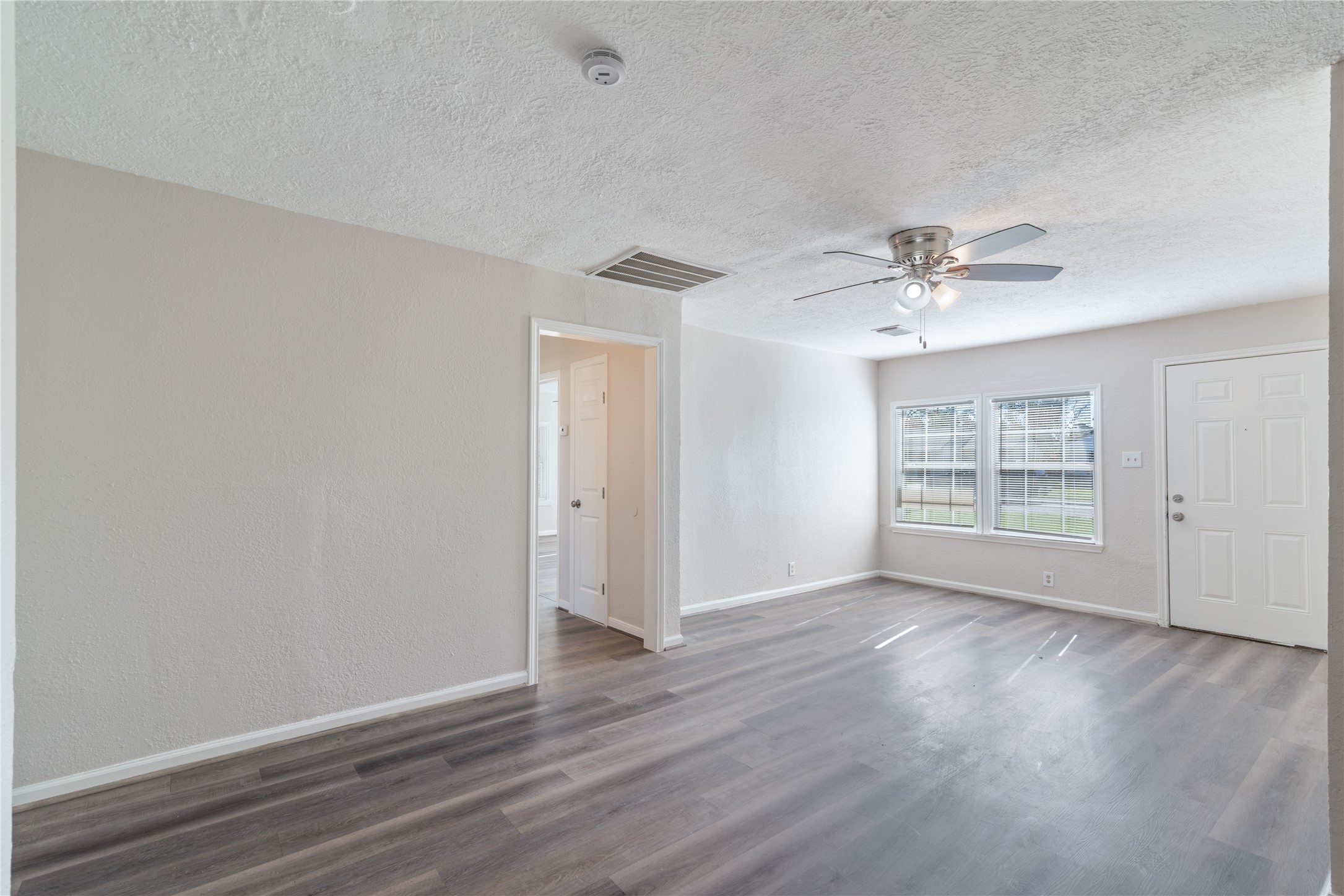 5825 Southurst Street Houston, TX 77033 - Photo 6 of 23 a view of an empty room with wooden floor and a window