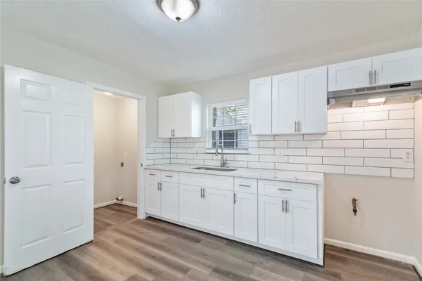 a kitchen with stainless steel appliances granite countertop a sink and cabinets with wooden floor