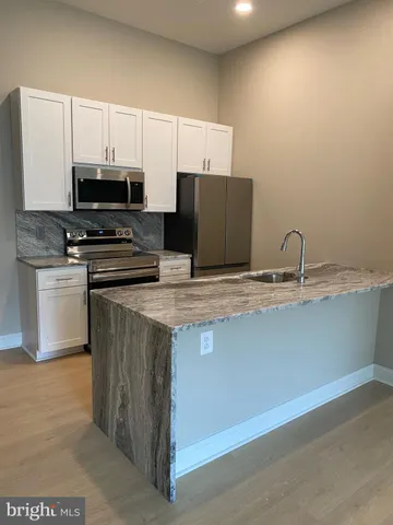 a kitchen with stainless steel appliances a stove a sink and a microwave