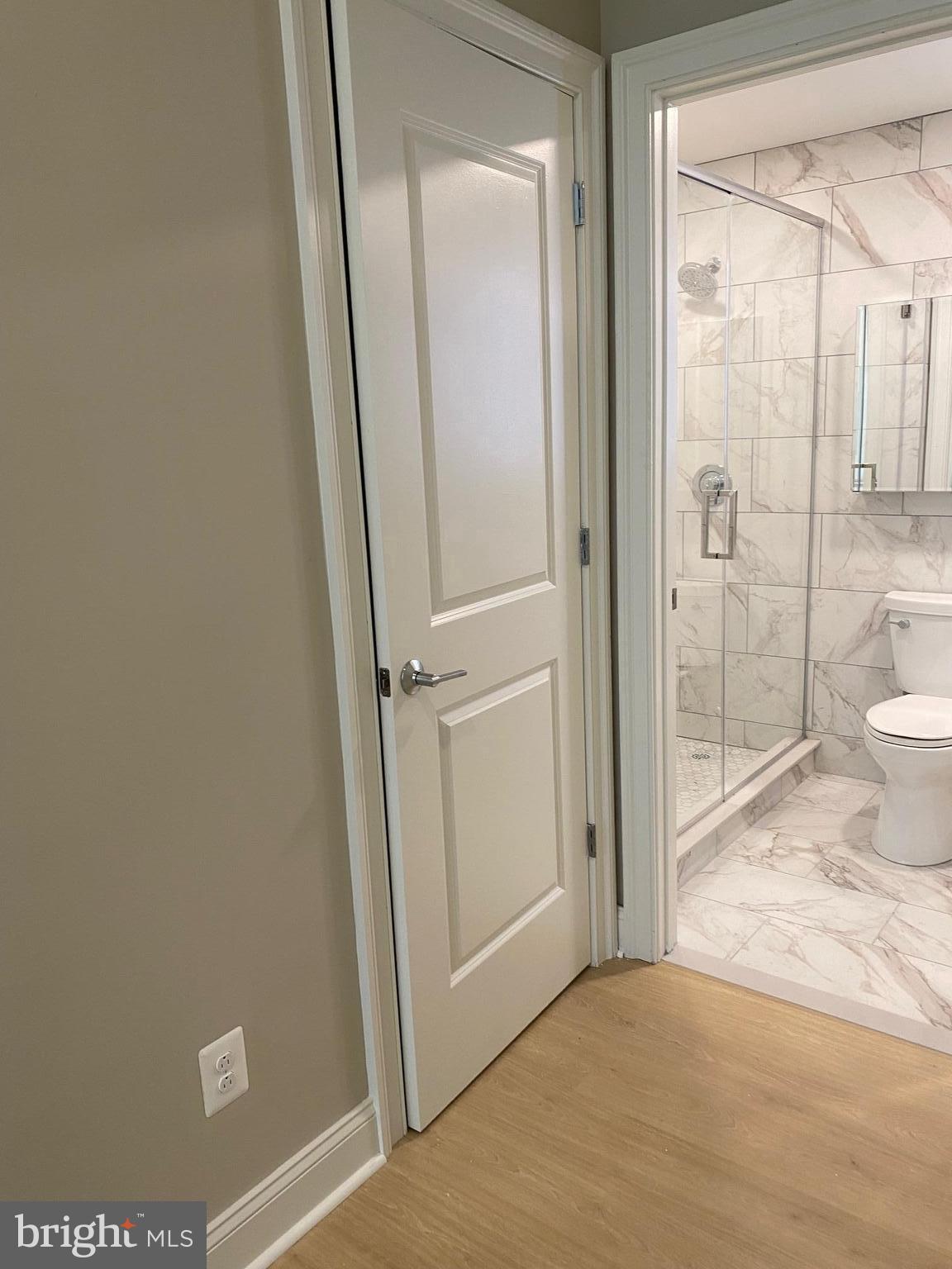 1900-20 Arch Street, Unit 109 Philadelphia, PA 19103 - Photo 10 of 34 a view of a bathroom with a glass door and a toilet