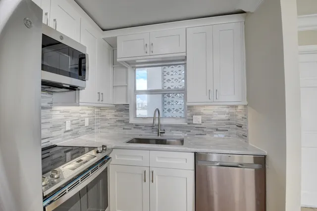 a view of a kitchen with refrigerator and windows