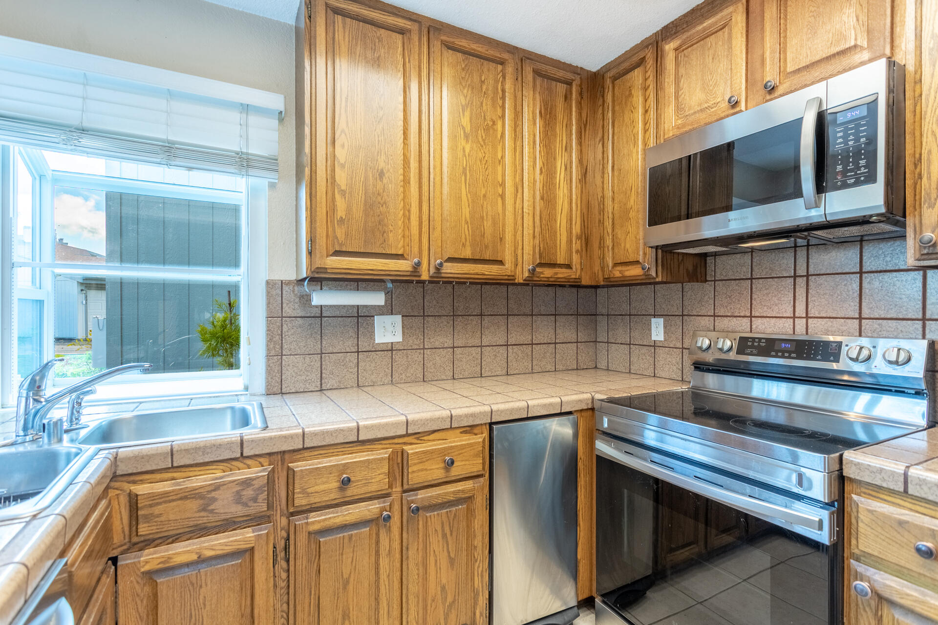 466 Ridgecrest Trail, Unit 136 Redding, CA 96003 - Photo 2 of 16 a kitchen with stainless steel appliances wooden cabinets a stove top oven a sink and dishwasher