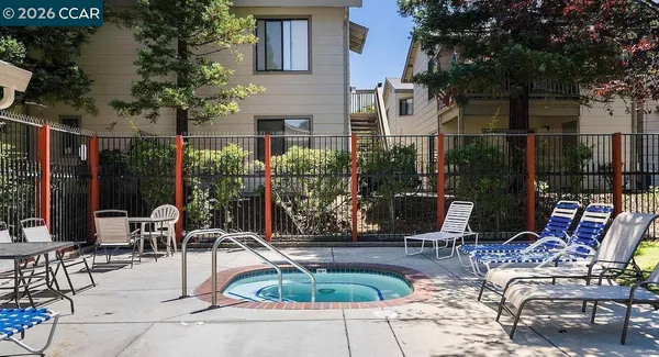 a view of a patio with table and chairs potted plants and large tree