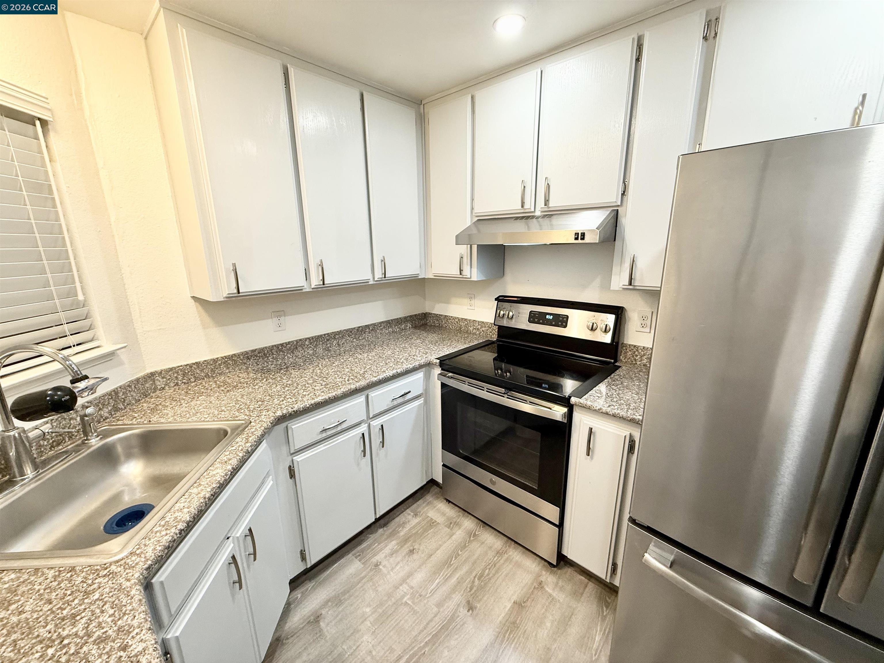 405 Weymouth Hercules, CA 94547 - Photo 4 of 22 a kitchen with granite countertop a sink stove and refrigerator