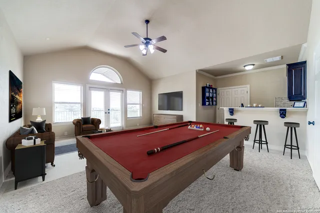 a room with furniture pool table and windows