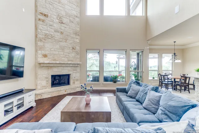 a living room with furniture large window and a fireplace