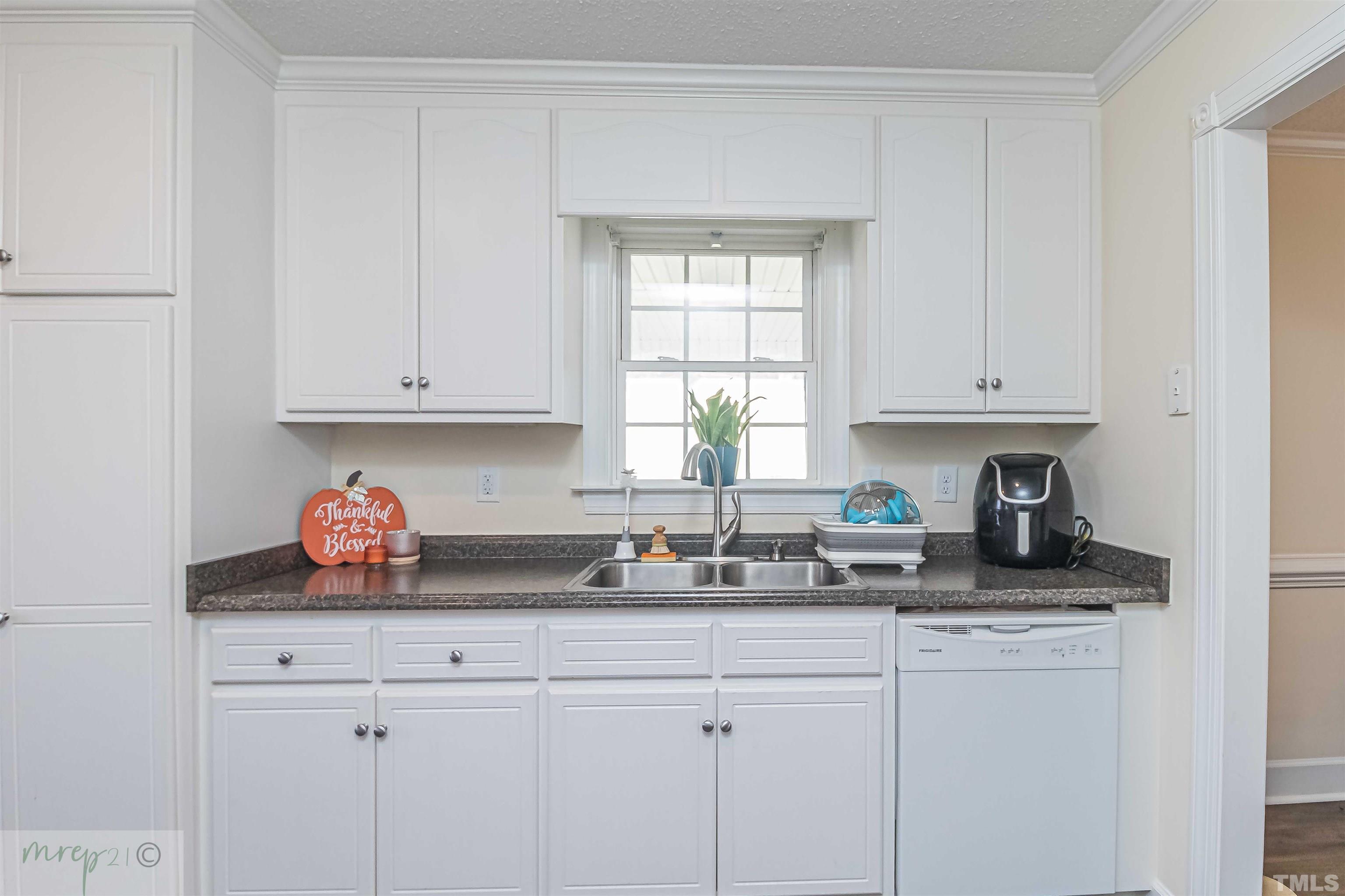 15838 Old Smithfield Road Sims, NC 27880 - Photo 11 of 27 a kitchen with stainless steel appliances granite countertop white cabinets a window and a sink
