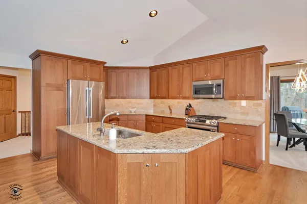 a kitchen with granite countertop a sink stove and refrigerator