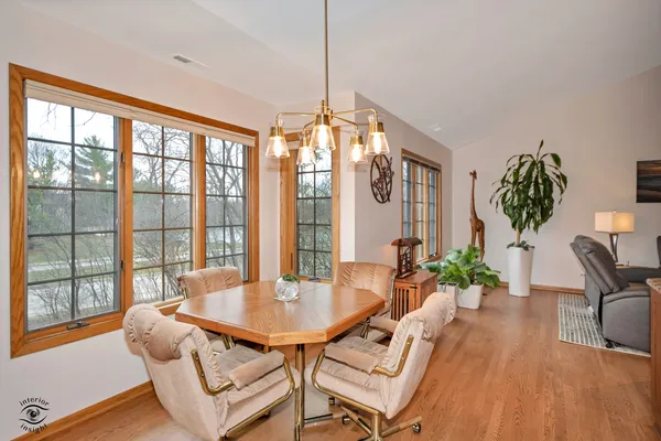 a dining room with furniture a chandelier and wooden floor