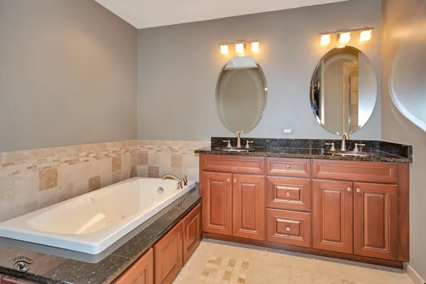 a bathroom with 2 sink tub and a mirror