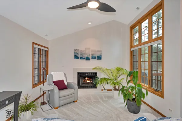 a living room with furniture fireplace and a large window