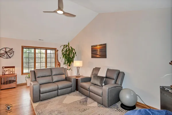 a living room with furniture a ceiling fan and a window