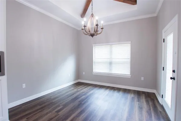 a view of empty room with wooden floor and window