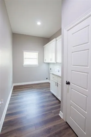 a kitchen with granite countertop white cabinets and a hard wood floors