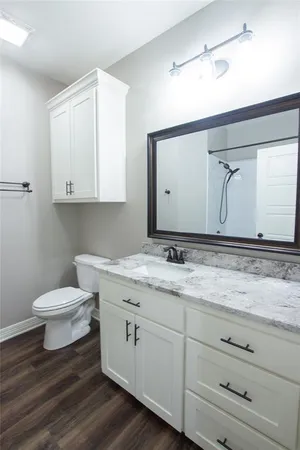 an empty room with wooden floor chandelier fan and windows