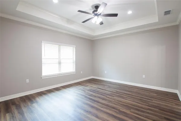 a view of an empty room with window and wooden floor