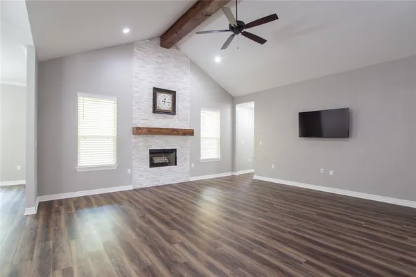 a view of empty room with wooden floor and fireplace