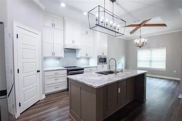 a kitchen with a sink cabinets and wooden floor