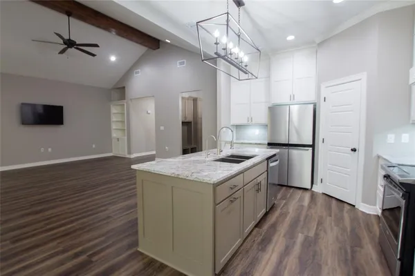 a kitchen with stainless steel appliances granite countertop a refrigerator a stove and a refrigerator