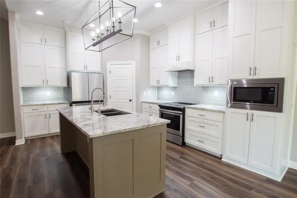 a kitchen with granite countertop cabinets stainless steel appliances and a counter space