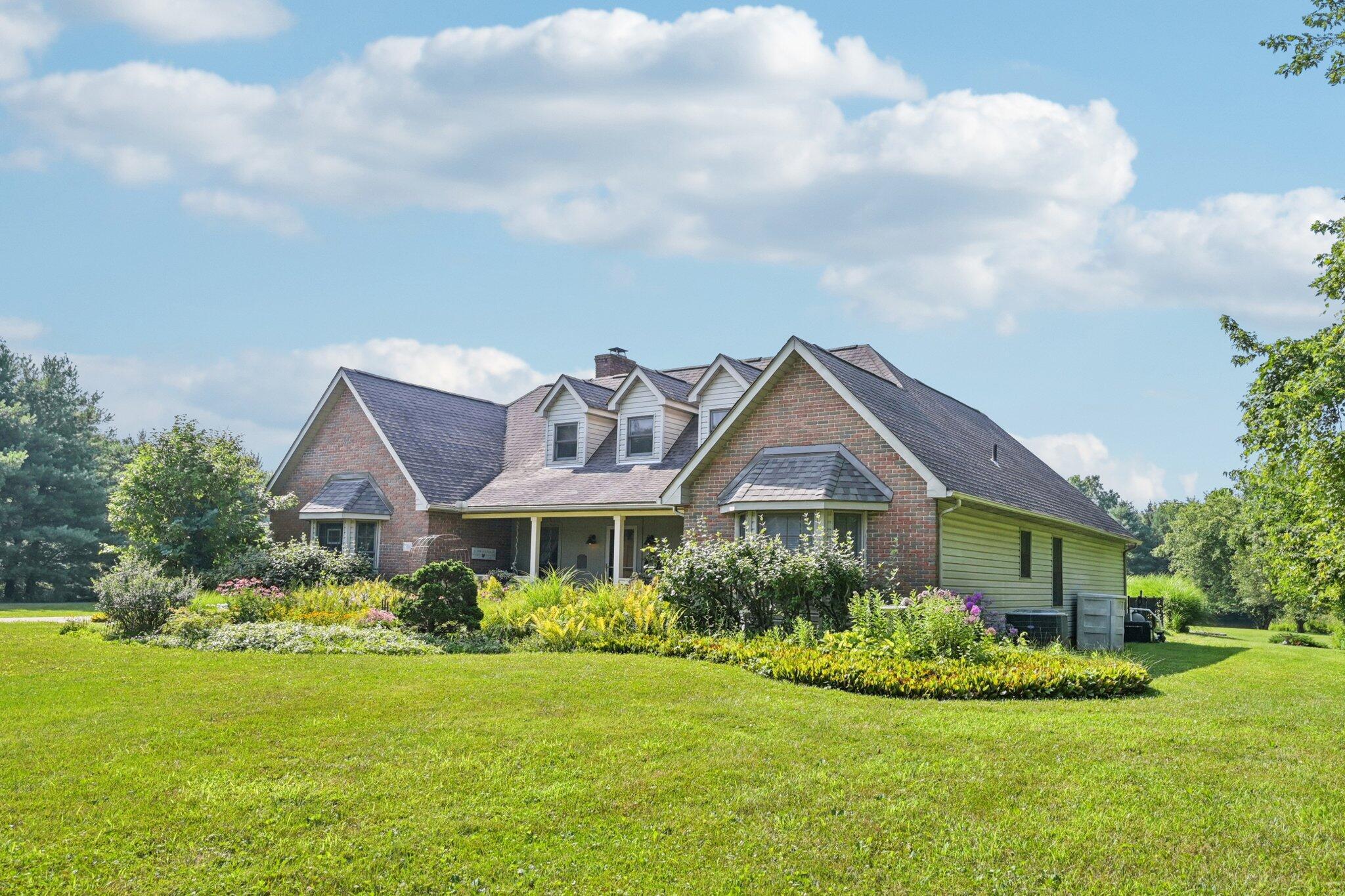 7700 Plumb Road Galena, OH 43021 - Photo 26 of 94 Rear corner view shows off lush perennial gardens and sweeping lawn—ideal for entertaining, play, or future outbuildings.