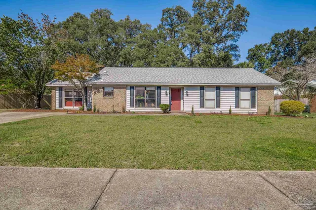 a spacious bedroom with a bed a chandelier and large window