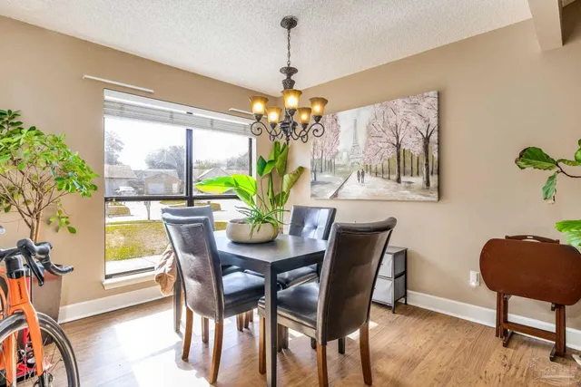 a dining room with furniture potted plants and wooden floor