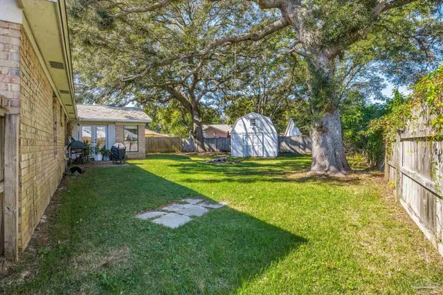 a view of a yard with large tree and wooden fence